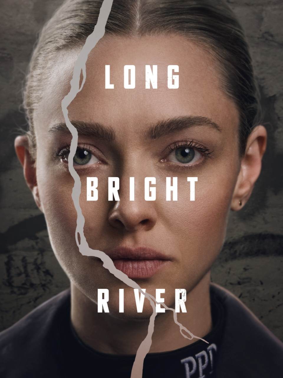 Poster for the series Long Bright River featuring Amanda Seyfried, her face split by a vertical tear; above it, the series title appears in large white letters.