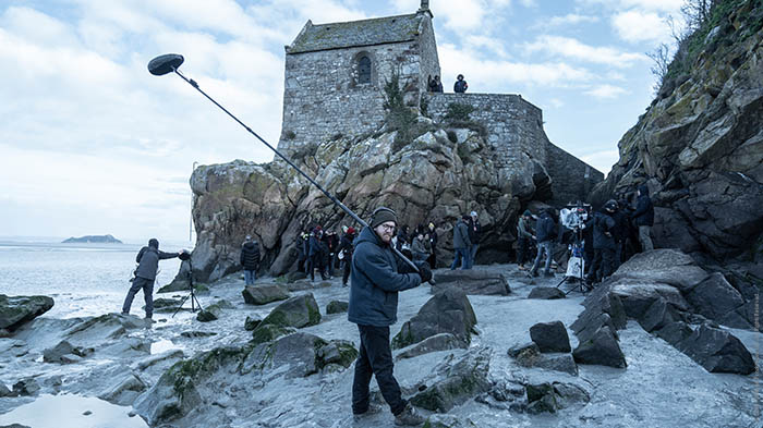 Die Crew positioniert sich auf den Felsen unter Saint Mont Michel.