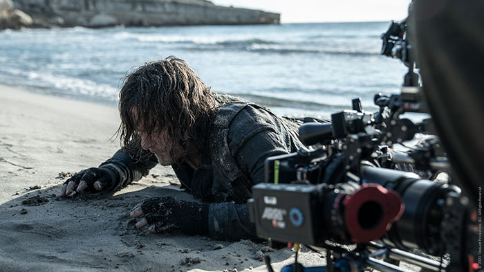 Norman Reedus kriecht aus dem Meer an den Strand, der Kameramann macht eine Nahaufnahme.
