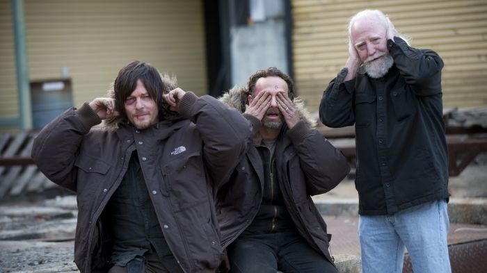 Behind-the-Scenes aus The Walking Dead: Norman Reedus (Daryl), Andrew Lincoln (Rick) und Scott Wilson (Hershel) posieren scherzhaft nach dem „Nichts hören, nichts sehen, nichts sagen“-Prinzip.